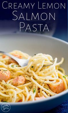 a white bowl filled with pasta covered in creamy lemon sauce and topped with shrimp