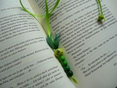 an open book with green beads and a smiley face on it