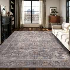 a living room filled with furniture and a rug on top of a hard wood floor