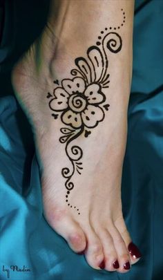 a woman's foot with a henna tattoo on it