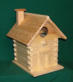 a small wooden birdhouse with a roof made out of wood