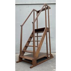 a wooden stair case sitting on top of a cement floor