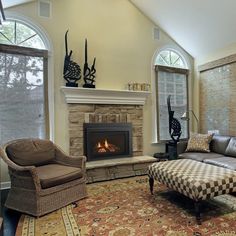 a living room filled with furniture and a fire place in the middle of a room