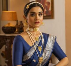 a woman in a blue sari with gold jewelry