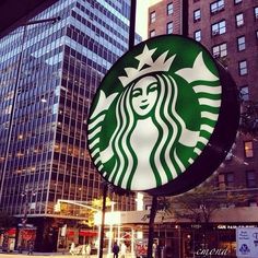 a starbucks sign in front of some tall buildings