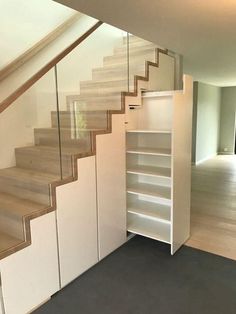 an empty room with stairs leading up to the second floor and another open space for storage