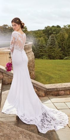 a woman in a wedding dress standing on some steps