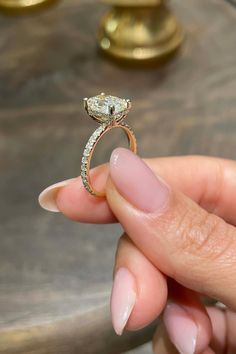 a person holding a diamond ring in their hand