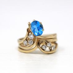 two gold rings with blue topaz and white diamonds