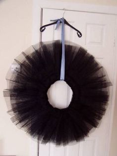 a black tutule hanging on a door with a blue ribbon attached to it