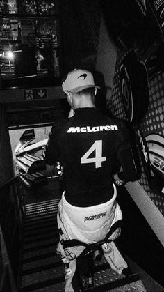 a man standing in front of a set of stairs wearing a number 4 shirt and hat