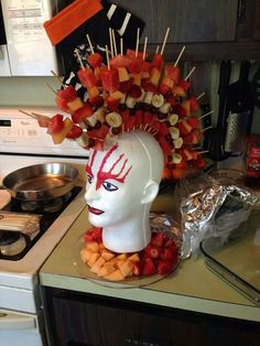 a head made out of food on top of a kitchen counter next to a stove