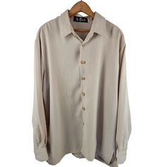 This Alan Stewart Men's Shirt is a size large, button-front, long sleeve garment. Made from polyester, it boasts a casual beige color. * Size: Large * Button-front design * Long sleeve * Made from durable polyester * Casual beige color Size: Mens L Measurements: Chest 48 in / 122 cm Length 30 in / 76 cm Condition: Pre-Owned  There are no stains, rips, or tears  Orders placed with be shipped either the same or the next business day Cream Long Sleeve Shirt With Button Closure, Cream Long Sleeve Shirt With Button Cuffs, Beige Long Sleeve Shirt With Button Cuffs, Cream Long Sleeve Shirt With Buttons, Beige Button-up Shirt With Button Closure, Beige Single Breasted Long Sleeve Top, Beige Long Sleeve Button Shirt, Beige Button-up Shirt With Button Cuffs, Large Buttons