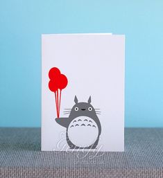 a card with a totoro holding a red balloon