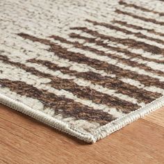 a brown and white rug on top of a wooden floor