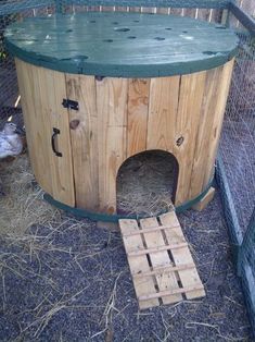 a cat house built into the side of a fenced in area with wood pallets