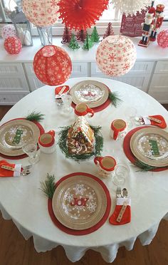 the table is set for christmas dinner with red and white decorations