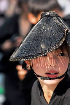 a young boy wearing a straw hat on top of his head in black and white