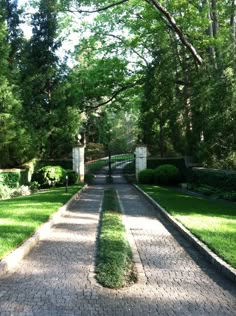 a brick walkway leads to a lush green park