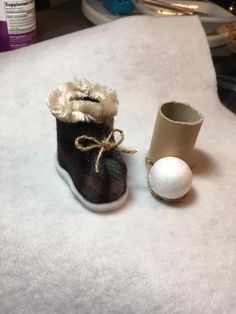 a pair of shoes and a roll of toilet paper sitting on a white tablecloth