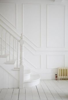 an empty room with white walls and stairs