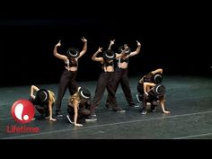 a group of people standing on top of a stage with their hands in the air