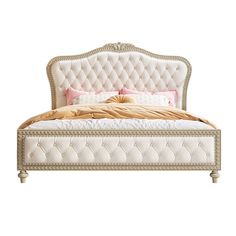 a white bed with an upholstered headboard and pillows on top of it