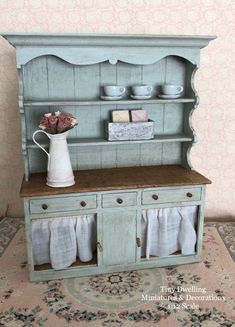 an old fashioned china cabinet with flowers on top