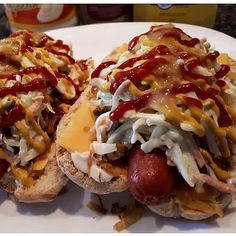 two hot dogs covered in condiments on a plate