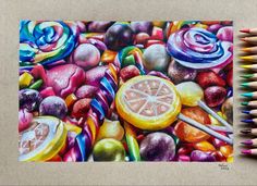 colored pencils next to a drawing of fruit and candy