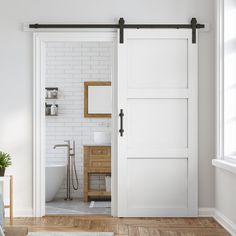 an open door leading to a bathroom with white walls and wood flooring, along with a sink