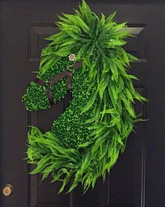 a green wreath hanging on the front door