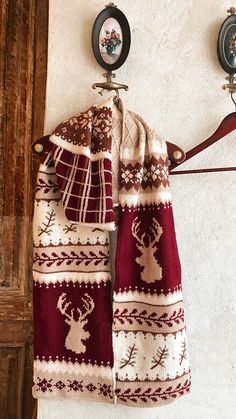 two towels hanging from hooks on a wall with an old fashioned coat hanger in the background