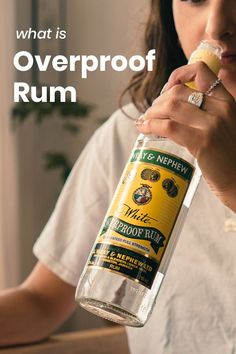 a woman holding a bottle of alcohol in her hand with the caption, what is overproof rum?