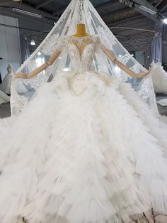 a white wedding dress on display in a room with mannequins and veils