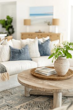 a living room filled with furniture and a plant on top of a wooden coffee table