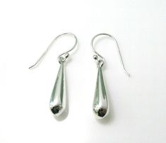 A Classic pair of sterling silver teardrop drop earrings from the Jewellery Box 925 Silver range each earring features a 3D droplet of silver.   32 mm (Inc Hook) x 5.5 mm at widest point  Supplied in a gift bag with free PP   Jewellery Box is a small family run jeweller's started in 2003 and based in The Historic "Arcade" in Letchworth Garden City Hertfordshire.  All our Jewellery is brand new and from our supplier's current collections.   We take great pride in our customer service and aim to d Letchworth Garden City, Wide Rings, Garden City, Thumb Rings, Fine Jewellery Earrings, Amethyst Stone, Tear Drop, Solid 925 Sterling Silver, Cross Pendant