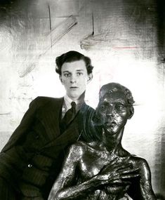 a woman sitting next to a bronze statue