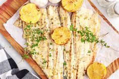 grilled fish with lemons and parsley on a cutting board