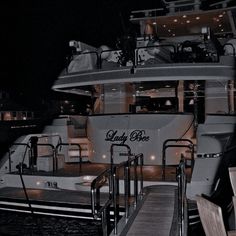 a boat docked at a dock with stairs leading to it and lights on the deck