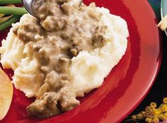 a red plate topped with mashed potatoes and gravy