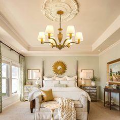 a bedroom with a large bed, chandelier and two lamps on the ceiling