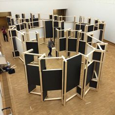 a group of people standing inside of a room filled with black and white walls on top of hard wood floors