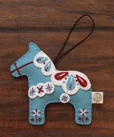 a blue horse ornament hanging on a wooden table