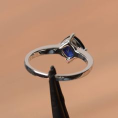 It is a lab sapphire ring. The main stone is 7 mm*7 mm cushion cut.weight about 1.94 carats. The basic metal is sterling silver and plated with rhodium. To change the metal to a solid gold (white/rose) or platinum is also available, please ask for a quotation if you want. You can also go to my shop Home for more elegant rings: https://www.etsy.com/shop/godjewelry?ref=hdr_shop_menu Sapphire is the September birthstone. More sapphire rings: https://www.etsy.com/shop/godjewelry?section_id=20715031 Cushion Cut Sapphire Sterling Silver Jewelry, Classic Silver Birthstone Ring With Lab-created Sapphire, Classic Silver Sapphire Ring With Lab-created Sapphire, Sapphire Sterling Silver Birthstone Ring, Round Cut, Elegant Square-cut Sapphire Ring In Sterling Silver, Blue Engagement Ring, Sapphire Wedding, Sapphire Engagement Ring Blue, Birthstone