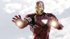 an iron man standing in the sky with his hands out