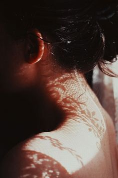 the back of a woman's head with sun shining on her skin and hair