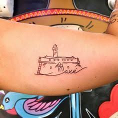 a person with a tattoo on their arm that has a castle drawn on it and is holding a teddy bear