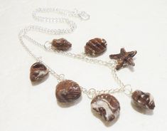 "Belgian Chocolate Seashell necklace. Grab yourself some yummy Belgian chocolate seashells, all ready to wear. Seven of your favourite seashells, to wear, not eat! Handmade from polymer clay, and varnished for a durable finish...they looks just like the real thing! The shells  are hanging from a silver plated 18\" chain. It's a little bit of Belgian chocolate heaven for you to wear. Please have a look at my other items- http://www.etsy.com/shop/GiraffesKiss" Handmade Brown Shell For Gift, Handmade Brown Shell Gift, Handmade Brown Shell As Gift, Handmade Brown Shell Necklace For Gift, Handmade Brown Shell As A Gift, Brown Shell Necklace As A Gift, Chocolate Seashells, Chocolate Necklace, Necklace Polymer Clay