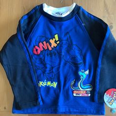 Perfect For A Young Pokmon Fan Or Collectors Alike! Near Perfect Condition, Tag Still Attached. Features Onix And Dragonair On The Front And Is Blank On The Back. Long Sleeve T-shirt With Character Print For Playtime, Black Cartoon Print Tops For Playtime, Black Tops With Cartoon Print For Playtime, Long Sleeve Character Print Playtime T-shirt, Blue Long Sleeve Top With Character Print, Black Long Sleeve Tops For Playwear, Flowy Shirts, Quilted Top, Boys Long Sleeve Shirts